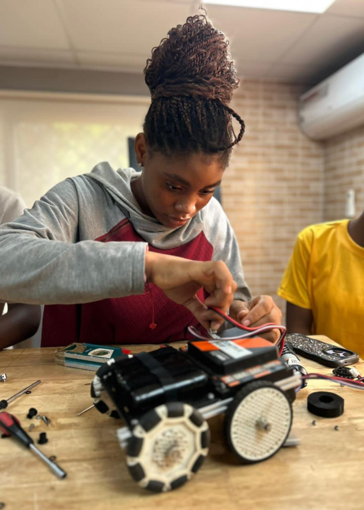 A young Liberian girl building a mini robot